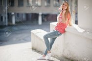 78288573-stylish-happy-blonde-woman-wear-at-jeans-sunglasses-and-t-shirt-posed-at-street-on-su...jpg