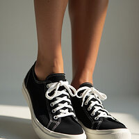 pikaso_texttoimage_photo-of-a-womans-feet-wearing-black-Keds-sneakers.jpeg